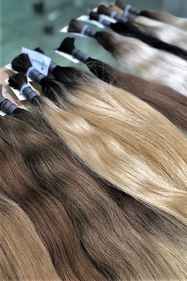 Bundles of hair extensions in shades from dark brown to blonde